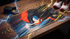 Mouse pad with a colorful design on a wooden surface with coins and shoes.

